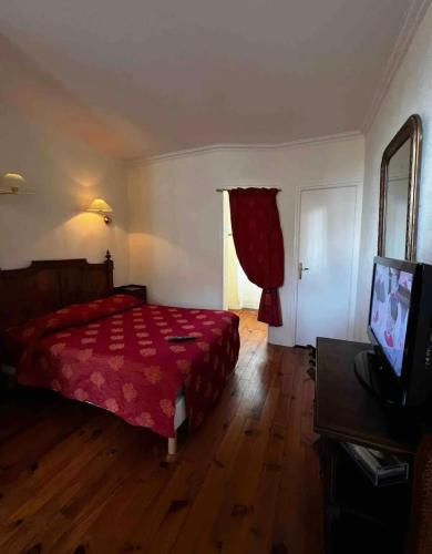 1 dormitorio con 1 cama, TV y puerta en Chez Vanessa, en Saint-Gervais-dʼAuvergne