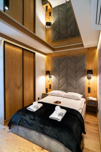 a bedroom with a large bed with two towels at Apartament Magiczne Podhale by Apart Concept Podhale in Kościelisko