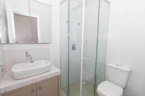 a bathroom with a toilet and a sink and a shower at 139C - lindo apartamento a 50m da praia de Canto Grande in Bombas