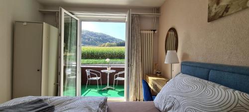 1 dormitorio con 1 cama y balcón con mesa y sillas en Edel Apartments Dulliken en Dulliken