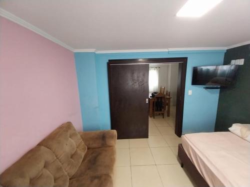 a bedroom with a couch and a bed and a door at Casa em Blumenau Oktoberfest e demais eventos até 13 pessoas in Blumenau