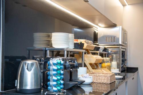 a kitchen with plates and dishes on a counter at Aila II Hotel Boutique by SingularStays - Digital Access in Burjasot