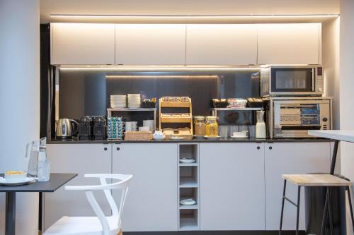 a kitchen with white cabinets and a counter with appliances at Aila II Hotel Boutique by SingularStays - Digital Access in Burjasot