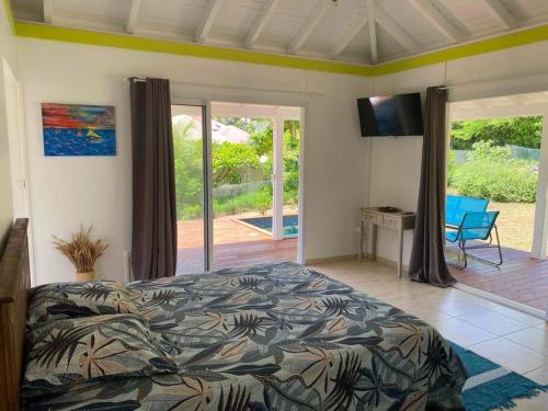 a bedroom with a bed and a view of a patio at Bungalow l'amandier avec piscine in Terre-de-Haut