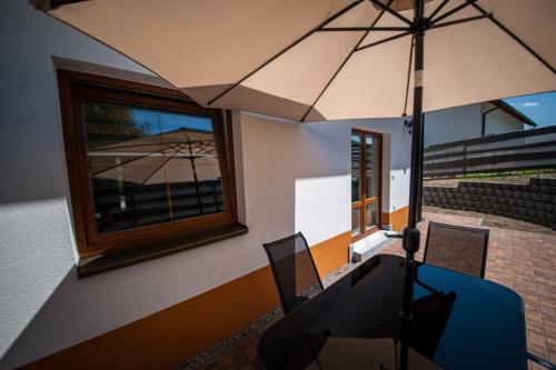 a dining room with a table and an umbrella at Apartmány na Žlábku in Horní Planá