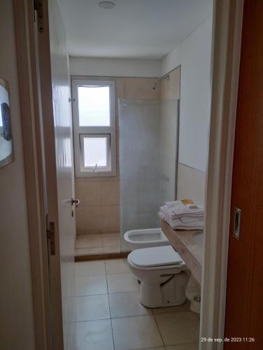 a bathroom with a toilet and a shower and a window at Marconi in Venado Tuerto