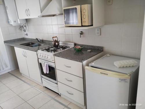 Una pequeña cocina con estufa y fregadero. en Marconi, en Venado Tuerto