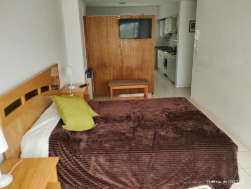 a bedroom with a large bed with a yellow pillow at Marconi in Venado Tuerto