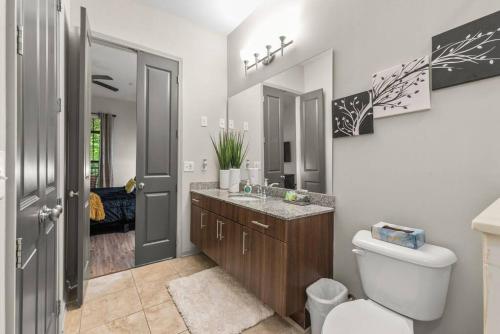 a white bathroom with a toilet and a sink at Luxe 2 Bedroom Oasis near Cobb and Truist Park in Atlanta