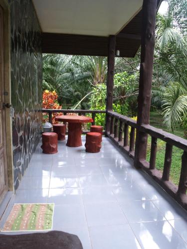 a patio with a table and chairs on a porch at Khao Sok Palmview Resort in Khao Sok