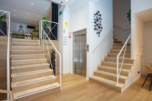 a staircase in a living room with wooden floors at Aila II Hotel Boutique by SingularStays - Digital Access in Burjasot