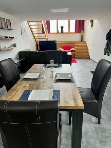 a dining room with a wooden table and black chairs at Capstay La Louvière in La Louvière