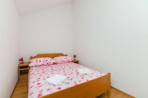 una camera da letto con letto e lenzuola e cuscini rosa di House Jozo a Marina