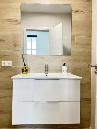 uma casa de banho com um lavatório branco e um espelho. em Ribera Home em Córdoba