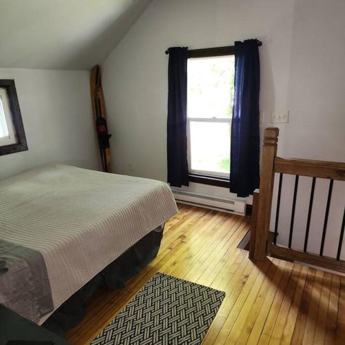 a bedroom with a bed and a window at Cottage on Shawano Lake. On The Beach in Shawano