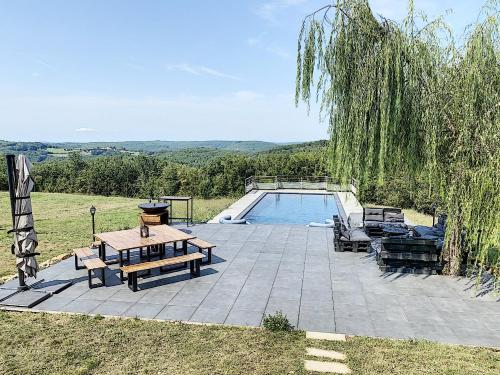 un patio avec une table et des chaises à côté d'une piscine dans l'établissement Domaine d'Orion, à Orliaguet