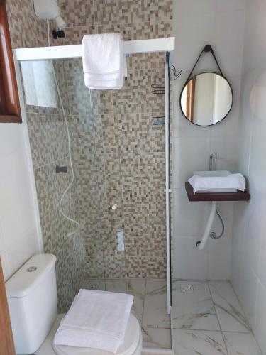 ein Badezimmer mit Dusche, Toilette und Waschbecken in der Unterkunft Casa das Pedras in Caraguatatuba