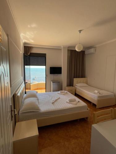 a bedroom with two beds and a view of the ocean at Hotel Tirona in Durrës