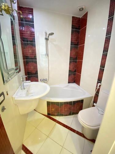 a bathroom with a sink and a tub and a toilet at فيلا اول صف بحر مارينا الساحل الشمالي العلمين برايفت بول in El Alamein