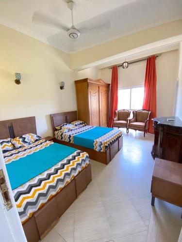 a bedroom with two beds and a living room at فيلا اول صف بحر مارينا الساحل الشمالي العلمين برايفت بول in El Alamein