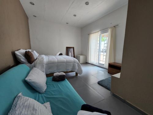 a bedroom with a large bed and a large window at Quinta las huertas in Tlajomulco de Zúñiga