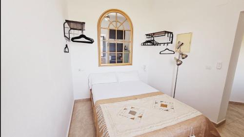 Habitación blanca con cama y ventana en Casa Bakara balcón de Vejer, en Vejer de la Frontera