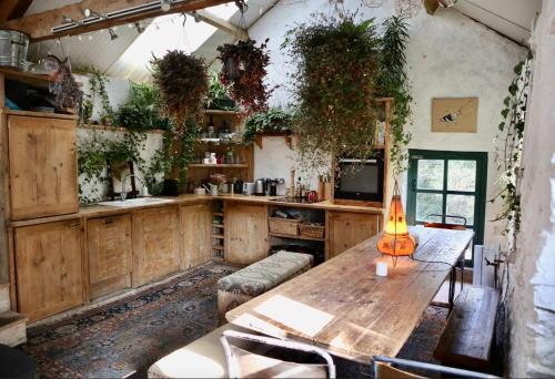 a kitchen with a wooden table in a room at 2 Luxury Yurts & Barn Kitchen Big Garden- Sleeps 9 in Llanelian-yn-Rhôs