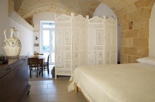 ein Schlafzimmer mit einem Bett und einem Tisch in einem Zimmer in der Unterkunft Residence Castello in Santa Cesarea Terme