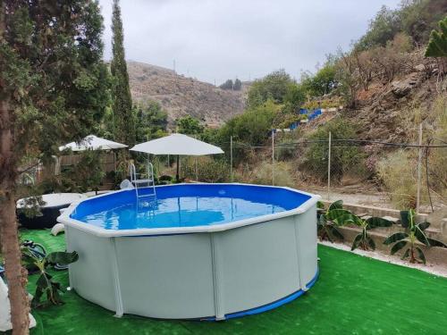 a large hot tub in the middle of a yard at Casa en el valle de GuainosAltos in Adra