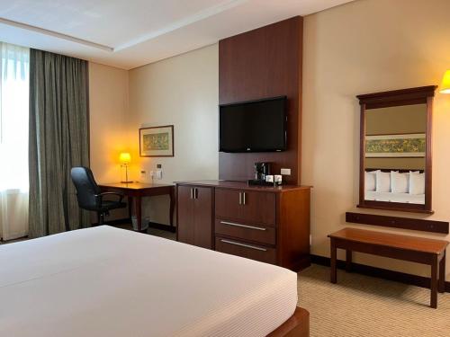 a hotel room with a bed and a flat screen tv at Eurobuilding Express Maracay in Maracay