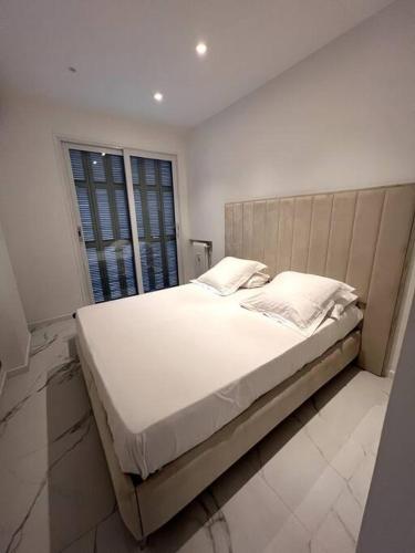un grand lit dans une chambre avec une fenêtre dans l'établissement Promenade Des Anglais 20m, à Nice