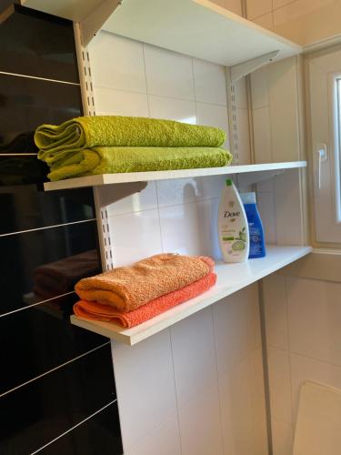 un armario con toallas y productos de limpieza en estanterías en comfortable apartment in a quiet area in the city center, en Skien