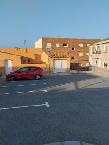 a red car parked in a parking lot at Apartamentos Canana de Vega in Flix