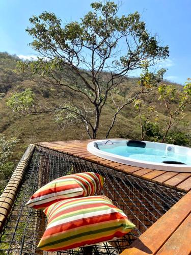 a hot tub on a roof with two pillows at Rustik in Alto Paraíso de Goiás
