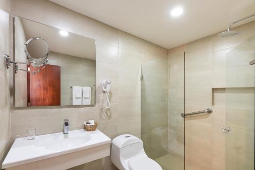 a bathroom with a toilet and a sink and a shower at Hotel Andes Plaza in Bogotá