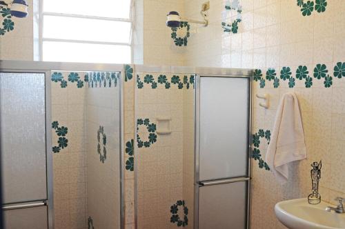La salle de bains est pourvue d'une douche et d'un lavabo. dans l'établissement Casa na quadra da Praia do Tenório, à Ubatuba
