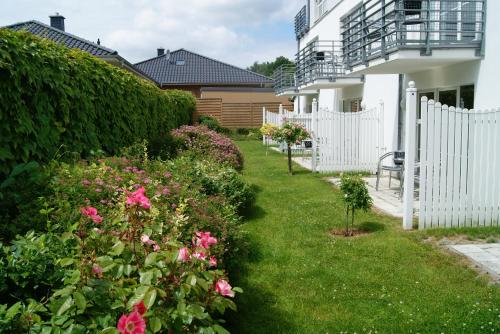 a garden with pink flowers and a white fence at Ferienwohnung im Haus Katharina in Lauterbach