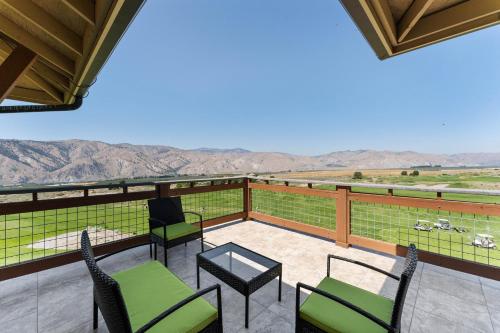 a balcony with chairs and a table with a view at Desert Canyon Golf Resort in Orondo