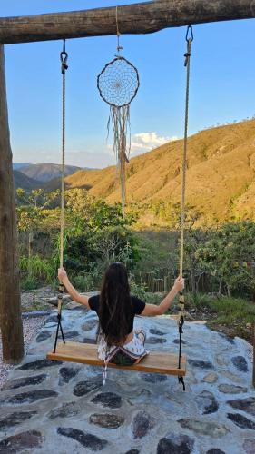 a woman is sitting on a swing at Rustik in Alto Paraíso de Goiás