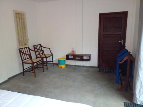 a room with two chairs and a table and a door at COCO RELAX AYURVEDA VILLAS in Hikkaduwa