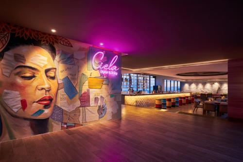 a restaurant with a large mural of a woman on the wall at voco Ma Belle Danang by IHG in Da Nang