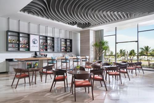 a restaurant with tables and chairs and a bar at voco Ma Belle Danang, an IHG Hotel in Da Nang