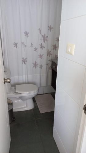 een badkamer met een toilet en een douchegordijn bij Depto La Serena frente al mar in La Serena
