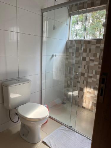 a bathroom with a toilet and a glass shower at Hotel Paraná Portal in Marechal Cândido Rondon