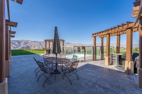a patio with a table with chairs and an umbrella at Desert Canyon Golf Resort in Orondo