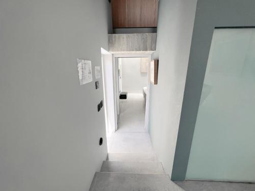 un pasillo en una casa con paredes blancas y una puerta en STUNNING AND SPACIOUS - 1BR PENTHOUSE, en La Valeta