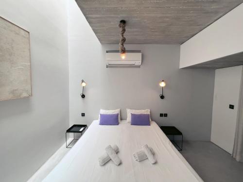a bedroom with a large white bed with purple pillows at STUNNING AND SPACIOUS - 1BR PENTHOUSE in Valletta