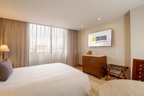 a bedroom with a large white bed and a window at Camino Real Aeropuerto in Mexico City