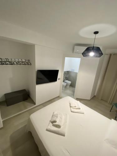 een witte slaapkamer met een bed en een hanglamp bij Casa vacanza Scala dei Turchi in Realmonte