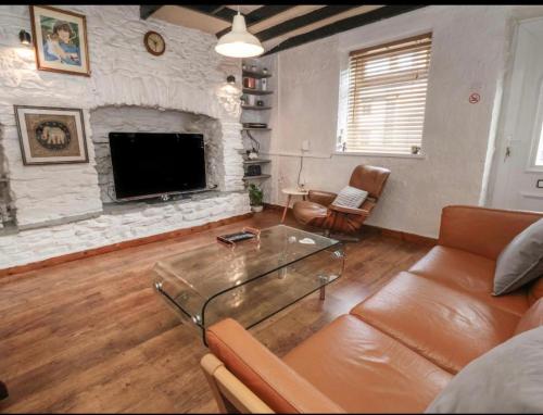 a living room with a couch and a fireplace at Coastal Village Cottage in Talacre